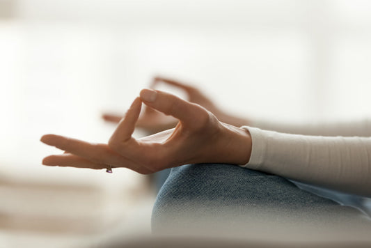 Close-up of hands in a meditation pose, symbolizing stress management and its impact on blood sugar control.